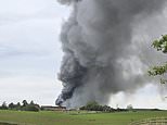 Fire crews battle massive chicken farm blaze as plumes of smoke are seen for miles around